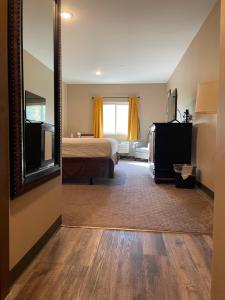a hotel room with a bed and a mirror at Wagon Wheel Yellowstone in West Yellowstone