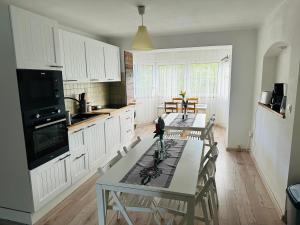 a kitchen with two tables and a kitchen with white cabinets at Gasthaus Radków in Radków