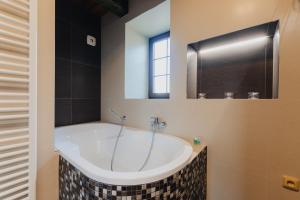 a bath tub in a bathroom with a window at Villa Jizbička in Náchod