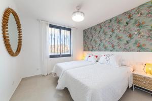two beds in a bedroom with a floral wallpaper at Los acantilados in Almería +24 photos