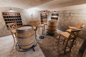 a wine tasting room with two barrels and chairs at Villa Jizbička in Náchod