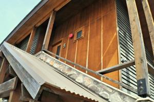 a wooden building with a balcony with a red ball on the door at Triggerplant 3 in Dinner Plain