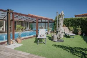 a backyard with a pool and a lawn with chairs and an umbrella at La Costana De Barbadillo in Barbadillo del Mercado