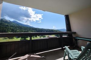 a balcony with chairs and a large window with a view at Cosy and nice view on mountains in Villard-de-Lans
