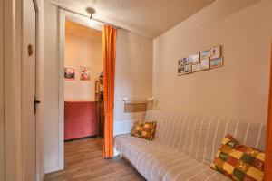 a living room with a couch and an orange curtain at Cosy and nice view on mountains in Villard-de-Lans