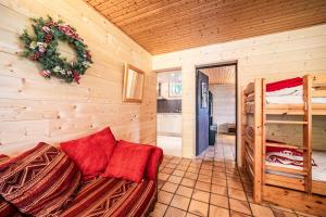 a log cabin with a couch and a bunk bed at Chalet la Bartavelle - Morillon in Morillon
