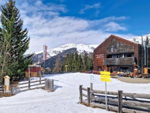 a building in the snow with mountains in the background at Apartment Naviser Hütte-2 by Interhome in Navis