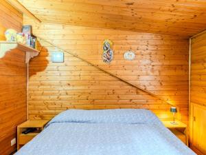 a bedroom with a bed in a wooden wall at Apartment Chalet Altavista by Interhome in Ziano di Fiemme