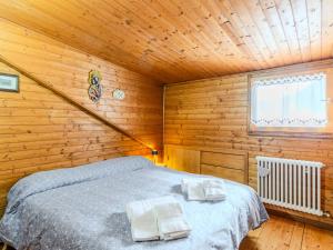 a bedroom with a bed in a wooden cabin at Apartment Chalet Altavista by Interhome in Ziano di Fiemme