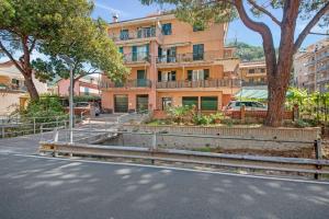 a building with a tree in front of a street at Un'oasi al Mare in Moneglia