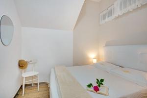 a white bedroom with a bed with a book on it at Un'oasi al Mare in Moneglia
