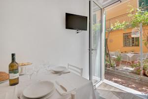 a white dining room with a table with a bottle of wine at Un'oasi al Mare in Moneglia