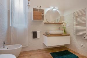 a white bathroom with a sink and a mirror at Un'oasi al Mare in Moneglia +21 photos
