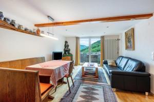 a living room with a table and a leather couch at Haus Michler in Todtnau