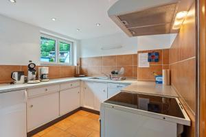 a kitchen with white cabinets and a sink at Haus Michler in Todtnau
