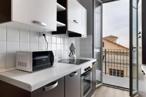 a kitchen with a microwave on a counter with a window at Puntodivista in Loano