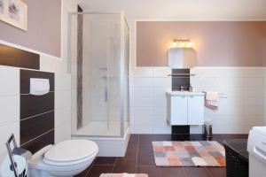 a bathroom with a toilet and a shower at Ferienwohnung Andresen Högel in Högel +19 photos