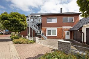 a brick house with a staircase on the side of it at To Hus an´t Water in Wunstorf