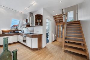 a kitchen with a staircase and a kitchen with white cabinets at To Hus an´t Water in Wunstorf