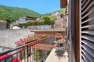 a balcony of a house with tables and flowers at La Casetta In Canada' in Agerola