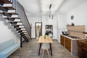 a living room with a table and a spiral staircase at La Casetta In Canada' in Agerola