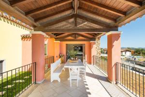 a patio with a table and a wooden pergola at Pretziosa in Castiadas