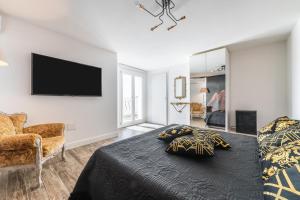 a bedroom with a bed and a flat screen tv at Villa Leon with Private Pool in Quartu SantʼElena