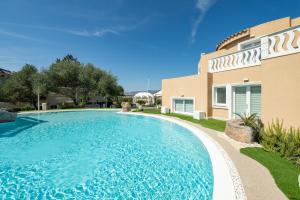 a swimming pool in front of a house at Villa Leon with Private Pool in Quartu SantʼElena