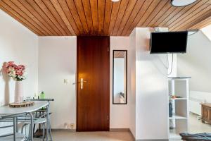 a living room with a wooden ceiling and a table at Storchennest in Ludwigsburg