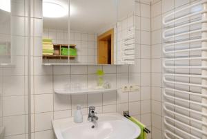 a white bathroom with a sink and a mirror at Ferienhaus Dünser in Bizau +35 photos