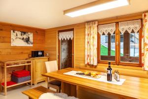 a dining room with a wooden table and windows at Ferienhaus Dünser in Bizau