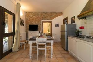 a kitchen with a table and a refrigerator at Podere Nuti - 1 La Regola in Cecina