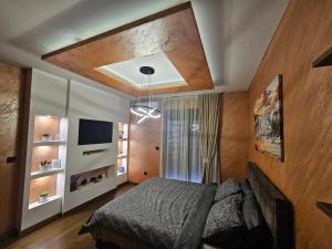 a bedroom with a bed and a television in it at Green Hills by MI in Podgorica