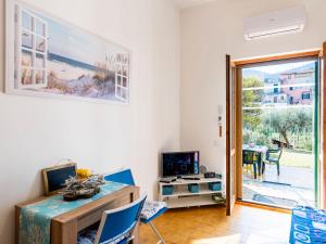 a living room with a desk and a sliding glass door at Apartment Marisol by Interhome in Toirano