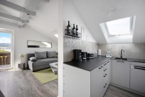 a kitchen and a living room with a couch at Loft mit Seeblick – Allgäu in Petersthal +26 photos