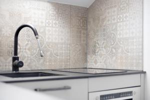 a kitchen with a sink and aaucet at Loft mit Seeblick – Allgäu in Petersthal