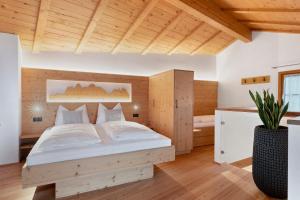 a bedroom with a bed in a room with wooden ceilings at Chalet Stieber in Feldthurns