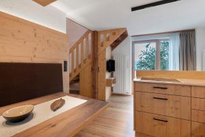 a kitchen with wooden counters and a wooden stair case at Chalet Stieber in Feldthurns