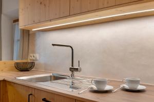 a kitchen sink with two cups on a counter at Chalet Stieber in Feldthurns +34 photos