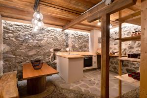 a kitchen with a stone wall and wooden ceilings at Chalet Stieber in Feldthurns