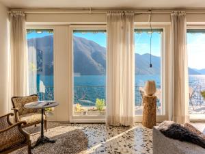 a living room with large windows and a view of the water at Villa Casa Silvana by Interhome in Valsolda