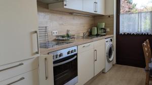 a kitchen with a stove and a washer and dryer at Ferienwohnung Eppler in Albstadt