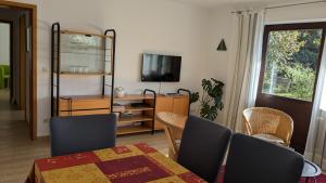 a dining room with a table and chairs and a television at Ferienwohnung Eppler in Albstadt