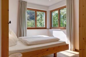 a bedroom with a bed in a room with windows at Baumannhof Villnöß in Funes