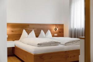 a bedroom with a large bed with white pillows at Appartement Sonnlicht Pfalzen in Falzes