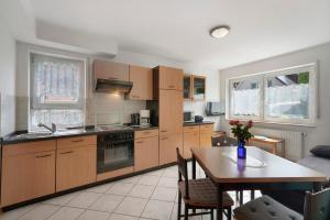 a kitchen with wooden cabinets and a table and a dining room at Haus Am Weinberg 2 in Endingen