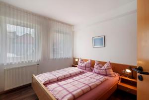 a bedroom with a bed with pink sheets and a window at Haus Am Weinberg 2 in Endingen