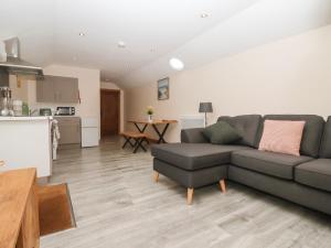 a living room with a couch and a kitchen at Honeybee Cottage in Hull +8 photos