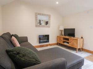 a living room with a couch and a television at Honeybee Cottage in Hull