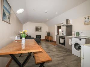 a kitchen and living room with a wooden table at Honeybee Cottage in Hull